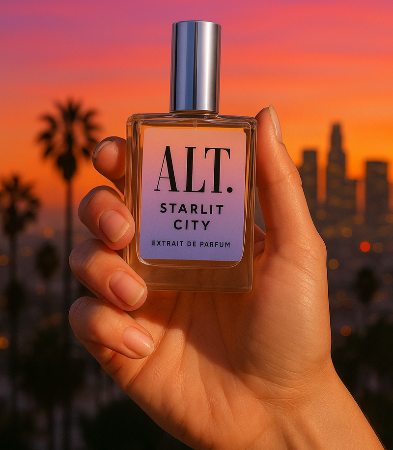 ALT. Starlit City perfume bottle a dupe for LV City of Stars being held in front of Sunset in LA. 